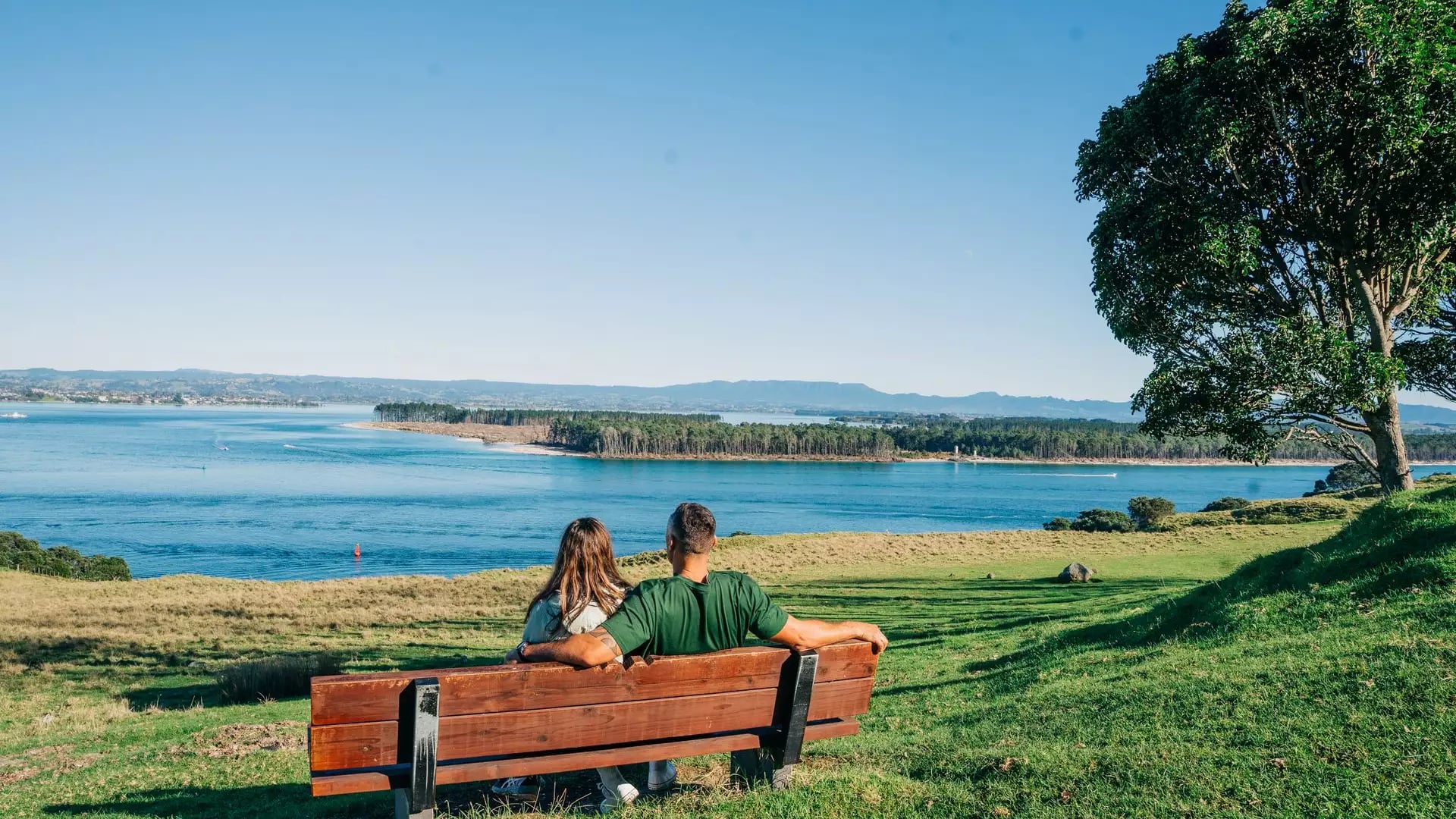 Couple at base of Mount Maunganui track looking at view.