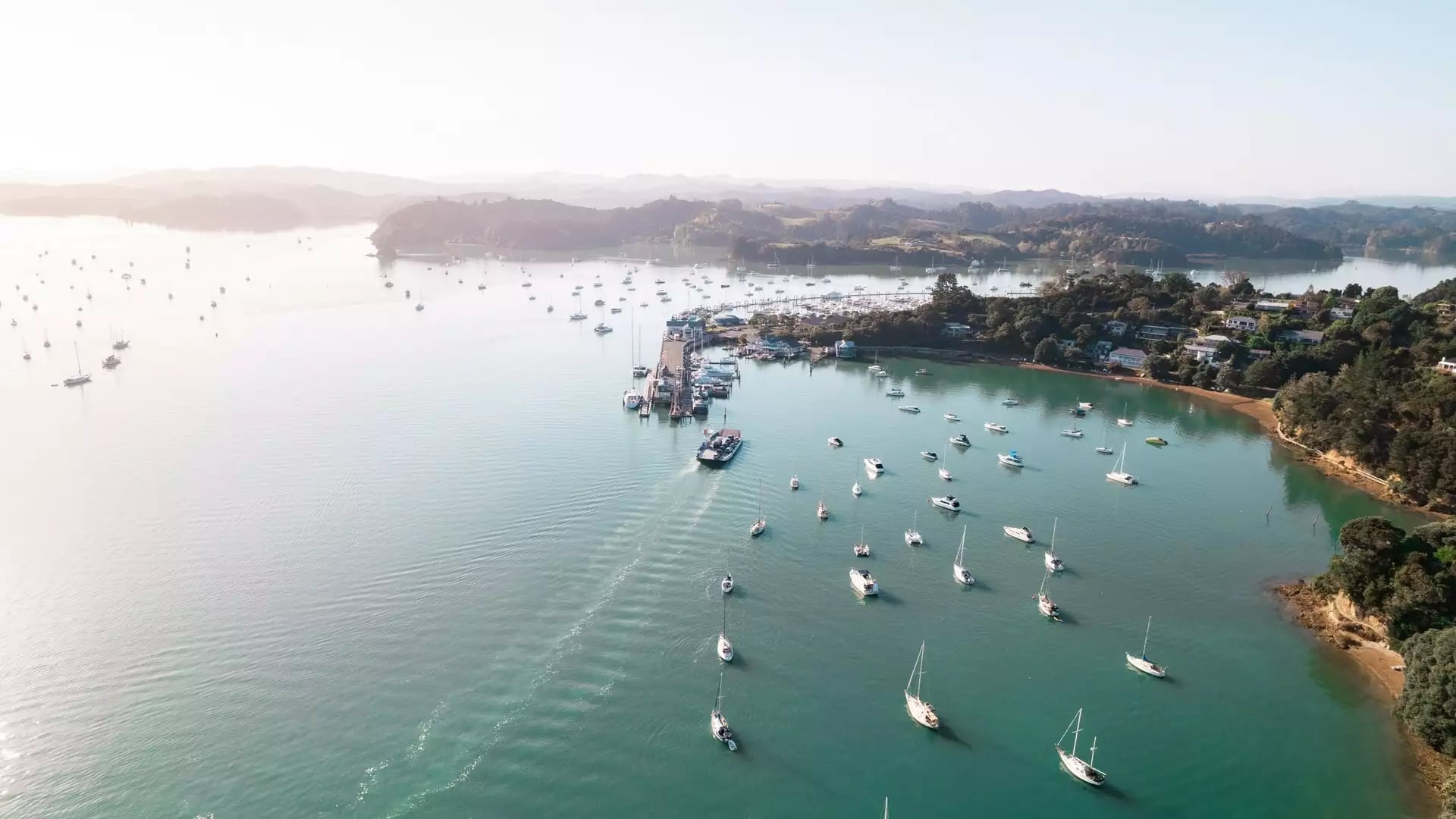 Aerial view of boats in a harbour in the Bay of Islands near a coastal town.