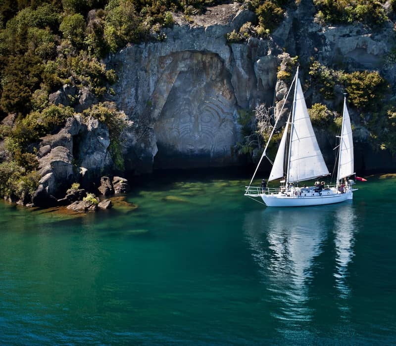 Sailing past Mine Bay Maori Rock Carvings.